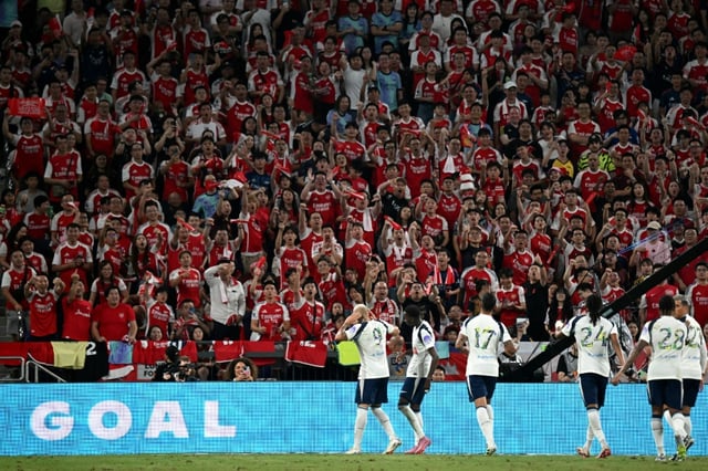 Tottenham Hotspur's players celebrate a goal in front of Arsenal fans during their friendly exhibition football match at the Kai Tak Stadium in Hong Kong on July 31, 2025.