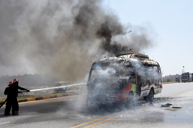 Firefighters try to douse a bus that caught fire during clashes with the supporters of Pakistan's former Prime Minister Imran Khan in Islamabad, Pakistan, May 12, 2023. REUTERS/Stringer/File Photo