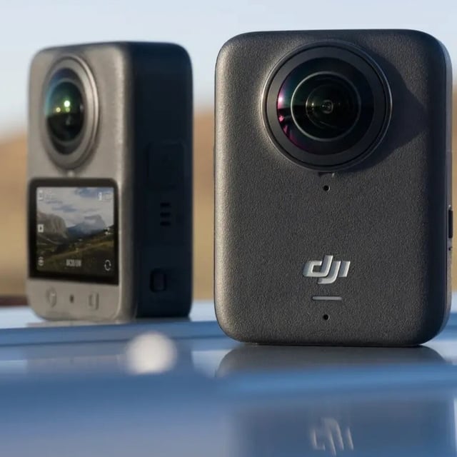 The DJI Osmo 360 camera sits on top of a car hood in the sun