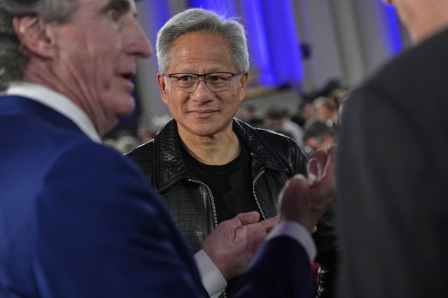 Nvidia CEO Jensen Huang talks with Interior Secretary Doug Burgum, left, before President Donald Trump speaks during an AI summit at the Andrew W. Mellon Auditorium, Wednesday, July 23, 2025, in Washington. (AP Photo/Julia Demaree Nikhinson)