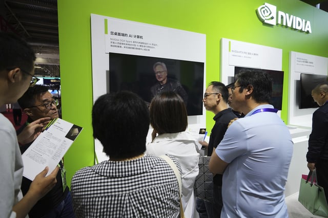 An exhibitor introduces the Nvidia DGX Spark to visitors at the Nvidia exhibition booth during the 3rd China International Supply Chain Expo at the China International Exhibition Center, in Beijing, Thursday, July 17, 2025. (AP Photo/Andy Wong)