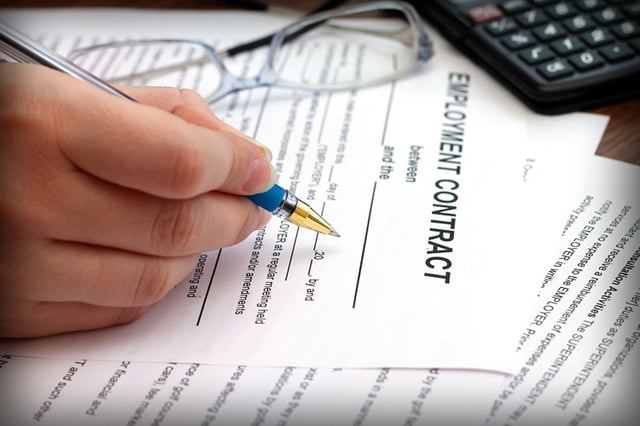 woman's hands signing an employment contract, close-up
