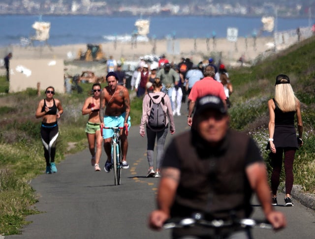 HUNTINGTON BEACH, CA - MARCH 28: People exercise along a bike path on March 28, 2020 in Huntington Beach, California. California Governor Gavin Newsom issued a ‘stay at home’ order on March 19 for California’s 40 million residents, with exceptions for essential activities, in order to slow the spread of COVID-19. (Photo by Michael Heiman/Getty Images)