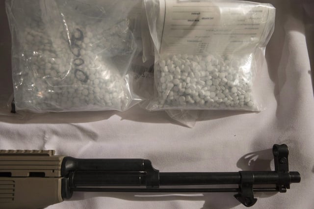 Bags containing fentanyl lie next to a firearm on a display table as Ontario Provincial Police host a news conference in Vaughan, Ont., on Thursday, Feb. 23, 2017. THE CANADIAN PRESS/Chris Young
