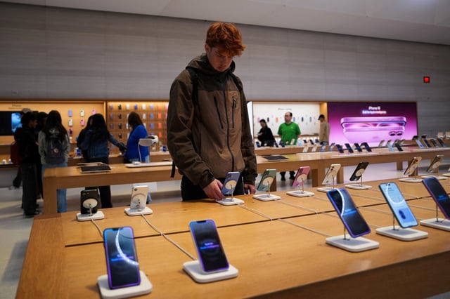 A person looks at iPhones in the Apple Fifth Avenue store in New York City, U.S., May 23, 2025. REUTERS/Adam Gray/File Photo