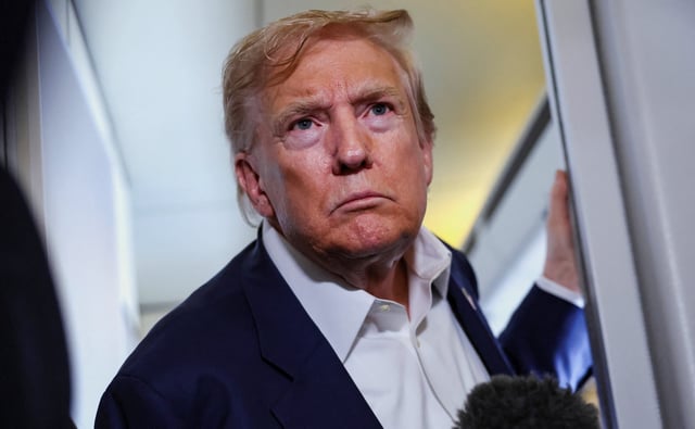 U.S. President Donald Trump reacts as he speaks to members of the media on board Air Force One en route from Scotland, Britain, to Joint Base Andrews, Maryland, U.S., July 29, 2025.