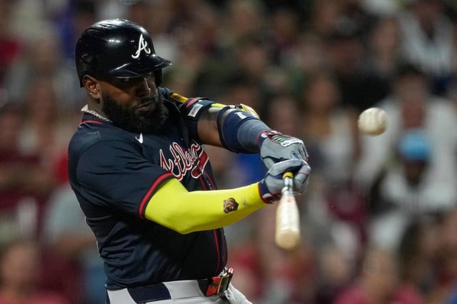 El bateador designado de los Bravos de Atlanta, Marcell Ozuna, conecta un elevado de sacrificio para que Matt Olson anote durante la décima entrada de un partido de béisbol contra los Rojos de Cincinnati, el jueves 31 de julio de 2025, en Cincinnati. (AP Photo/Carolyn Kaster)