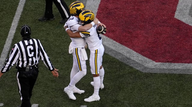 Michigan Wolverines quarterback Davis Warren (16) and Michigan Wolverines wide receiver Tyler Morris (8) embrace following a 13-10 win over the Ohio State Buckeyes in Saturday’s NCAA Division I football game at Ohio Stadium.