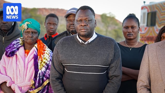 A Sudanese family gathered at the outback search scene, with the father in the front.