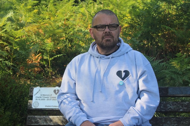 Martin Cosser sits on a memorial bench with a plaque honouring Charlie, Cosser's son, who was killed in a knife attack, at Devil's Punch Bowl, in Surrey, England, July 16, 2025. REUTERS/Catarina Demony/File Photo