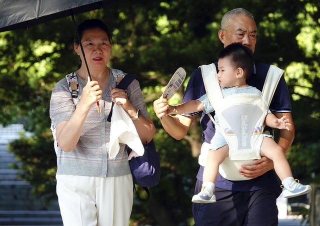 Grandparents take a toddler into a park in Yichang city in central China&#39;s Hubei province Tuesday, July 29, 2025. China has introduced a nationwide childcare subsidy program starting in 2025, as part of broader efforts to support families and encourage childbirth.