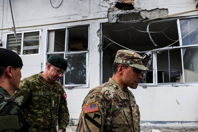 U.S. and Canadian military attaches walk near a damaged hospital, caused by shelling in Sisaket province, as they inspect the site, following a ceasefire between Cambodia and Thailand, Thailand, August 1, 2025. REUTERS/Chalinee Thirasupa