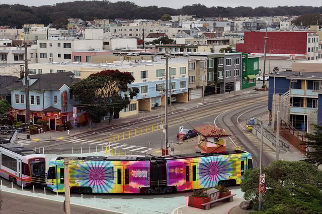 In an aerial view, an SF Muni N Judah train is seen wrapped in tie-dye colors on July 28, 2025, in San Francisco.
