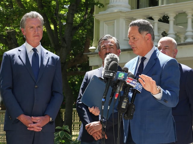 California Gov. Gavin Newsom, left, listens as Texas state Representative Rafael Anchia, center discusses the Republican redistricting efforts in Texas, during a news conference In Sacramento, Calif., Friday July 25, 2025. Newsom is calling for a new method for California to redraw it&#39;s voting boundary lines, to ensure more Democrats in Congress. 