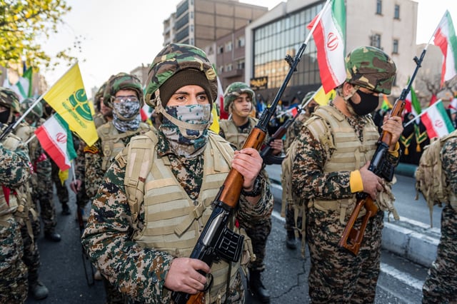 Basij militants, wearing military uniforms, hold a variety of rifles and the flags of Hezbollah and Iran during a parade of an alleged 110,000 paramilitary Basij and IRGC (Islamic Revolutionary Guard Corps) forces in downtown Tehran, Iran, on January 10, 2025.