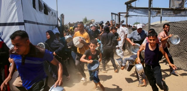 Des Gazaouis se ruent sur une distribution d'aide alimentaire à Khan Younès, dans le sud de la bande de Gaza, le 22 juillet 2025