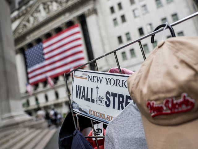 FILE PHOTO: A Wall Street plate is seen on a street vendor stall outside the New York Stock Exchange (NYSE) in New York City, U.S., July 11, 2025. REUTERS/Jeenah Moon/File Photo