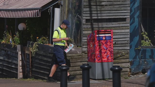 Unionized workers at Canada Post are entering their final day to vote on the Crown corporation's latest contract offer. A Canada Post employee prepares to check a street letter box while delivering mail, in White Rock, B.C., on Monday, July 28, 2025. The Canadian Union of Postal Workers is urging they reject the proposal. THE CANADIAN PRESS/Darryl Dyck