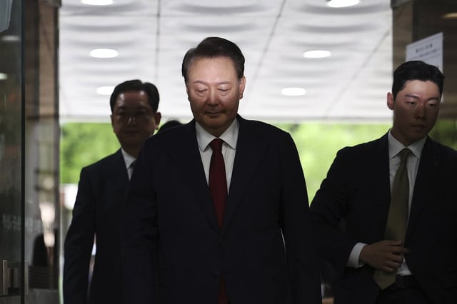 Former South Korean President Yoon Suk Yeol, centerm arrives at a court to attend a hearing to review his arrest warrant requested by special prosecutors in Seoul, South Korea Wednesday, July 9, 2025. 