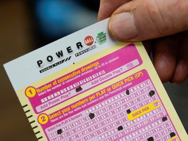 FILE - A person shows their scan card for their personal selection numbers for a ticket for a Powerball drawing on Nov. 7, 2022, at a convenience store in Renfrew, Pa. A winning ticket has been sold in California for Wednesday's drawing on July 19, 2023, for the Powerball jackpot worth $1 billion. (AP Photo/Keith Srakocic, File)