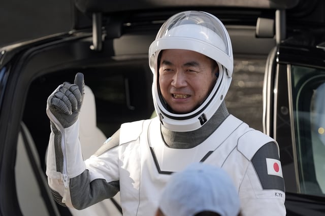 Astronaut Kimiya Yui, of Japan gestures as he leaves the Operations and Checkout Building for a trip the Kennedy Space Center's Launch Pad 39-A and a planned liftoff on a SpaceX Falcon 9 rocket Friday, Aug. 1, 2025, in Cape Canaveral , Fla. (AP Photo/John Raoux)