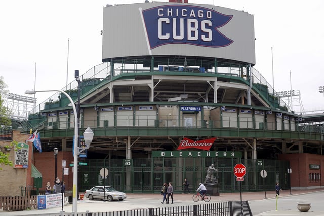 Pedestrians walk in the Wrigleyville neighborhood outside the Chicago Cubs home stadium of Wrigley Field in Chicago, Illinois, U.S. May 20, 2020. REUTERS/Joshua Lott/File Photo