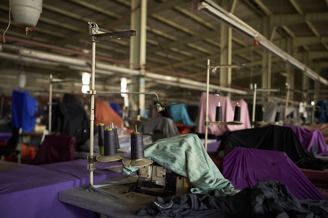 A sewing machine is covered by a sheet inside the empty Tzicc clothing factory following the threat of U.S.-imposed tariffs in Maseru, Lesotho, Tuesday, July 22, 2025. (AP Photo/Bram Janssen)