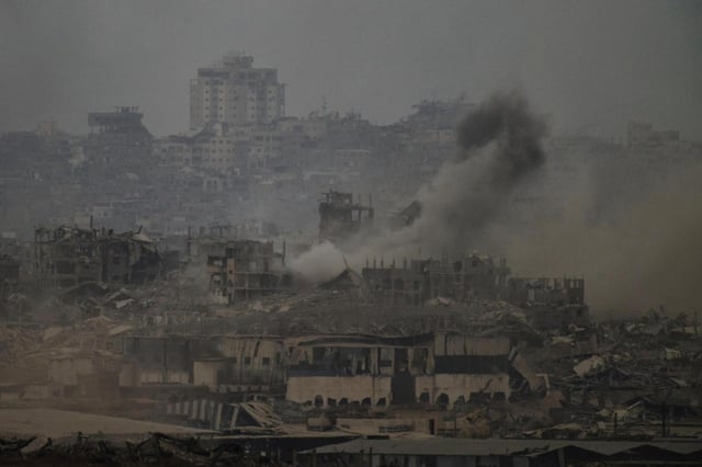 Humo se eleva entre edificios destruidos tras un bombardeo israelí en la Franja de Gaza, visto desde el sur de Israel, el viernes 1 de agosto de 2025. (AP Foto/Leo Correa)