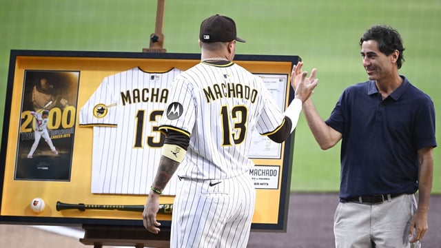 Jul 8, 2025; San Diego, California, USA; San Diego Padres third baseman Manny Machado (13) shakes hands with general manager A.J. Preller after receiving commemorative memorabilia recognizing his 2,000th hit before a baseball game against the Arizona Diamondbacks at Petco Park. Mandatory Credit: Denis Poroy-Imagn Images