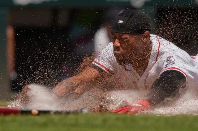 Will Benson de los Rojos de Cincinnati se desliza a salvo a home para anotar con un sencillo de Matt McLain durante la sexta entrada de un partido de béisbol contra los Bravos de Atlanta, el viernes 1 de agosto de 2025, en Cincinnati. (AP Photo/Carolyn Kaster)
