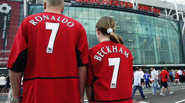 Manchester United fans wearing new boy Cristiano Ronaldo and recently departed David Beckham shirts