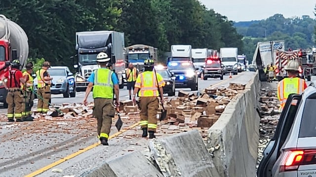 Rescue crews clean up a truckload of hot dogs that spilled out of a tractor-trailer on August 1, 2025, along Interstate 83 in Shrewsbury, Pa.