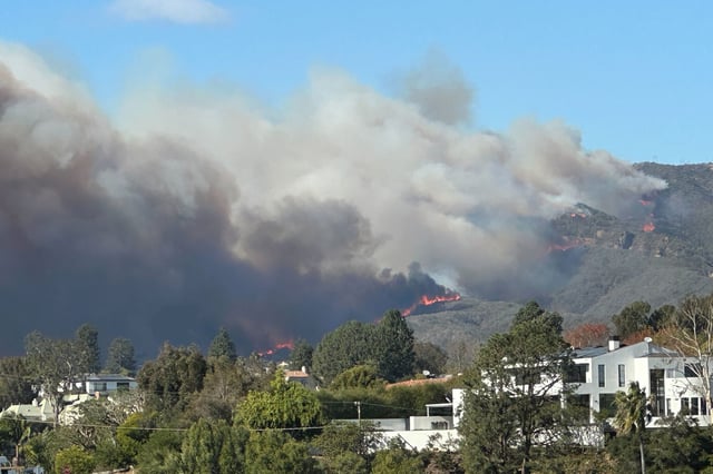 Smoke and flames from the Palisades Fire form the backdrop to homes in Santa Monica, as seen on Jan. 7. 