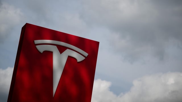 Das Tesla-Logo steht an einem Autohaus.