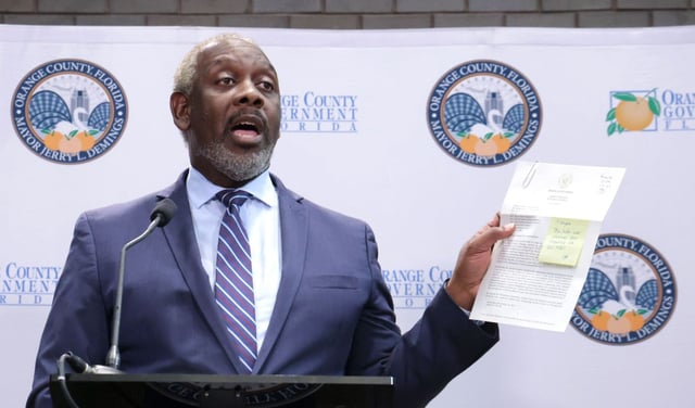 Orange County Mayor Jerry Demings holds a copy of a letter from Florida Attorney General James Uthmeier warning of penalties the mayor and county commissioners could face if they did not approve an amendment to a cooperative agreement with ICE. The amendment would allow county jail officers to transport ICE detainees to federal detention facilities hundreds of miles away. (Joe Burbank/Orlando Sentinel)