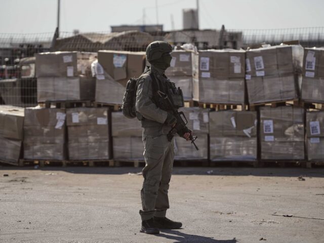 FILE - An Israeli soldier stands beside humanitarian aid packages awaiting pickup on the Palestinian side of the Kerem Shalom crossing in the Gaza Strip, Thursday, July 24, 2025, during a media tour organized by the Israeli army. (AP Photo/Ohad Zwigenberg, file)