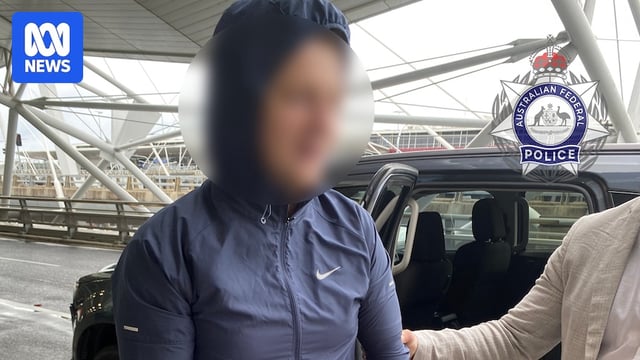 a blurred photo of a man being put into handcuffs