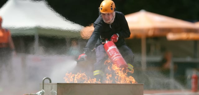 Eine Feuerwehrsportlerin trainiert im Hafenstadion in Torgau das Löschen eines Flüssigkeitsbrandes