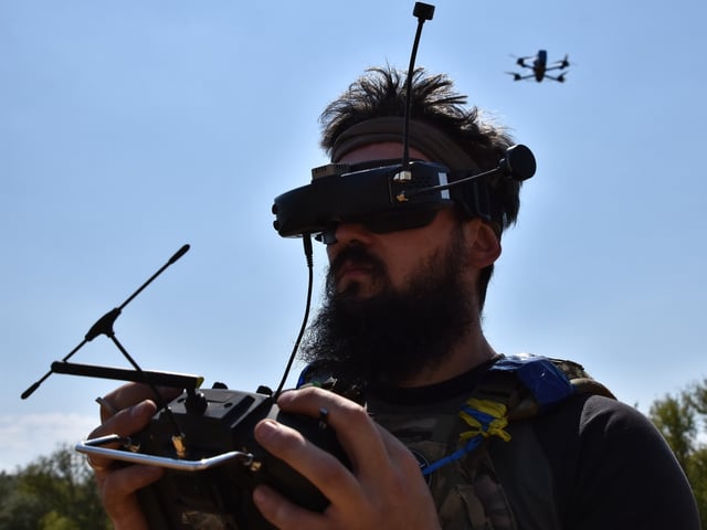 ZAPORIZHZHIA, UKRAINE - 2024/07/29: A drone operator of the 15th Brigade (Kara-Dag) of the National Guard of Ukraine seen with a FPV (first-person view) kamikaze drone on a wheat field after a military training exercise. The mass use of FPV (first-person view) drones in hostilities between Ukrainian and Russian forces has radically changed the pattern of modern war. Successful use of one or more cheap drones makes it possible to destroy equipment worth millions of dollars. The military uses FPV drones as kamikaze drones and installs various warheads on them. On the other hand, FPV kamikaze drones are precision weapons that are capable of striking various armoured vehicles and destroying enemy manpower. (Photo by Andriy Andriyenko/SOPA Images/LightRocket via Getty Images)