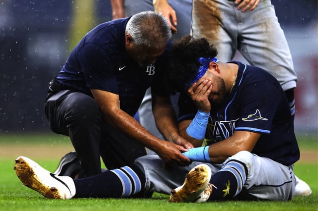 Jonathan Aranda es atendido tras fracturarse la muñeca izquierda al intentar poner out a Giancarlo Stanton, de los Yankees de Nueva York. (Foto: AP Photo/Heather Khalifa)
