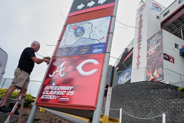 Rod Bruchell instala carteles en el exterior del Bristol Motor Speedway, el viernes 1 de agosto de 2025, en Bristol, Tennessee, el día antes del partido de béisbol del Clásico de Béisbol en el Speedway de la MLB entre los Rojos de Cincinnati y los Bravos de Atlanta. (AP Photo/George Walker IV)