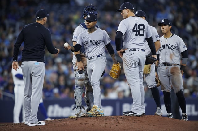 TORONTO, CANADA - APRIL 17: Marcus Stroman #0 of the New York Yankees hands the ball to Aaron Boone, manager of the New York Yankees, as he leaves the game in the sixth inning of their MLB game against the Toronto Blue Jays at Rogers Centre on April 17, 2024 in Toronto, Canada.