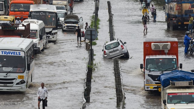 Vehicles wade through a waterlogged stretch after heavy rain on the National Highway-48 near Narsinghpur village, in Gurugram.
