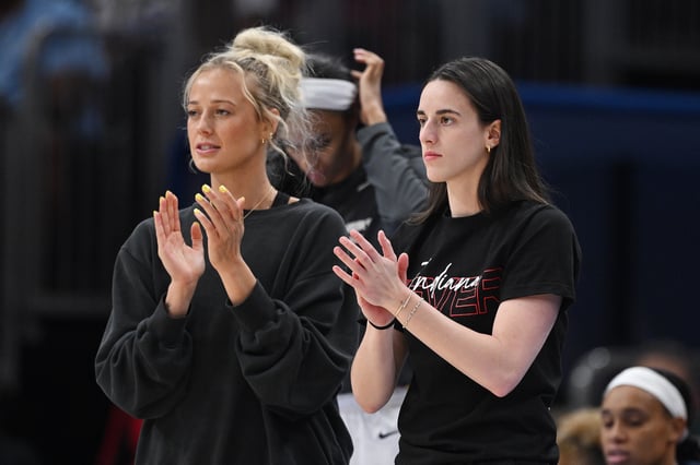 Sophie Cunningham #8 and Caitlin Clark #22 of the Indiana Fever cheer from the bench against the Chicago Sky at the United Center on June 07, 2025 in Chicago, Illinois.