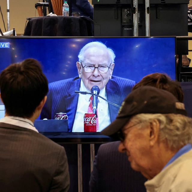 FILE PHOTO: People watch as Berkshire Hathaway chairman Warren Buffett is seen on a screen speaking at the Berkshire Hathaway Inc annual shareholders' meeting, in Omaha, Nebraska, U.S., May 3, 2025.  REUTERS/Brendan McDermid/File Photo