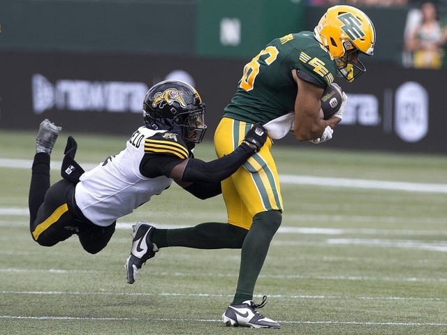 The Edmonton Elks' Arkell Smith (86) is tackled by the Hamilton Tiger-Cats' Reggie Stubblefield (1) during CFL action at Commonwealth Stadium, in Edmonton Saturday, Aug. 2, 2025. 