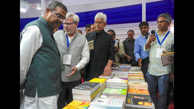 Union education minister Dharmendra Pradhan with Jammu and Kashmir Lt governor Manoj Sinha at a stall during inaugural ceremony of the 'Chinar Book Festival', at SKICC in Srinagar, Saturday. (PTI)