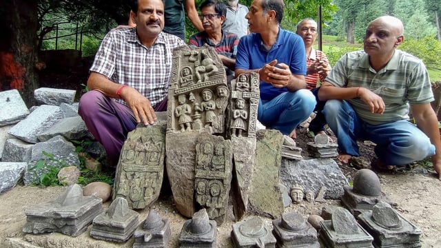 Officials with the ancient idols discovered during excavation at a shrine in Anantnag district of J&K on Saturday, August 2.