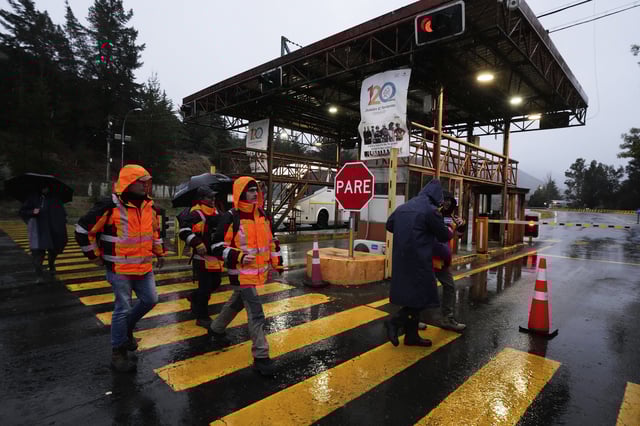 Workers walk at the entrance of El Teniente copper mine, operated by Codelco in Chile, where a collapse killed one worker and trapped five others underground, leading to a suspension of operations in Rancagua Chile, Friday, Aug. 1, 2025. (AP Photo/Esteban Felix)