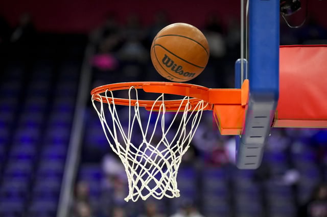 A detail of a basketball hoop and net with a Wilson brand official NBA game ball basketball before the game between the Detroit Pistons and Charlotte Hornets at Little Caesars Arena on February 09, 2025 in Detroit, Michigan.